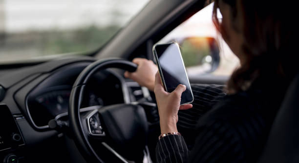 istock Young woman using smart phone mobile phone in car while driving. 1420359957