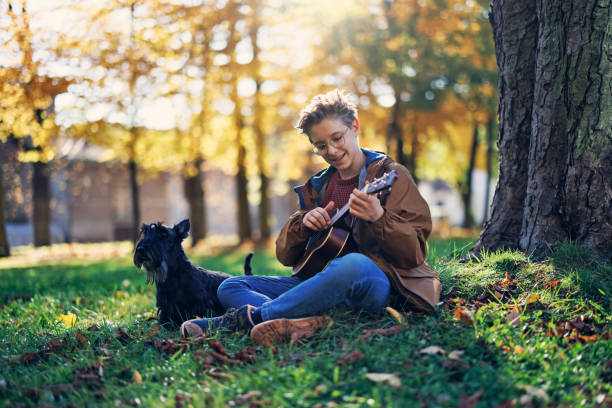 istock Little boy and his dog playing in public park 1420362564