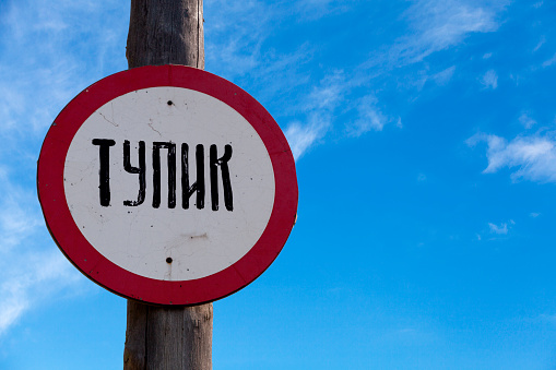 Russian Dead end sign () against a clear blue sky.