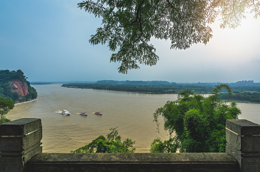 Three sightseeing boats with tourists sailing on the Min River and Dadu River in Leshan, as seen from the scenic lookout located above the Giant Budda, the southern part of Sichuan province, China