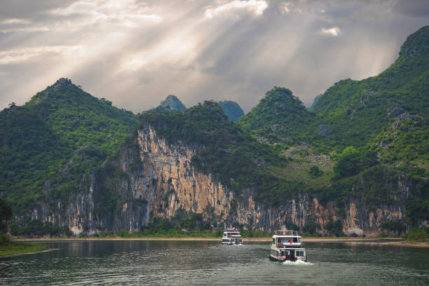 bateaux de touristes naviguant sur une rivière li en chine - yangshou photos et images de collection