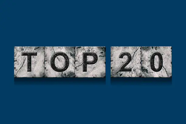 Photo of Top 20, words, isolated on a dark blue background. Alphabet on stone blocks.Rating. Rating concept.