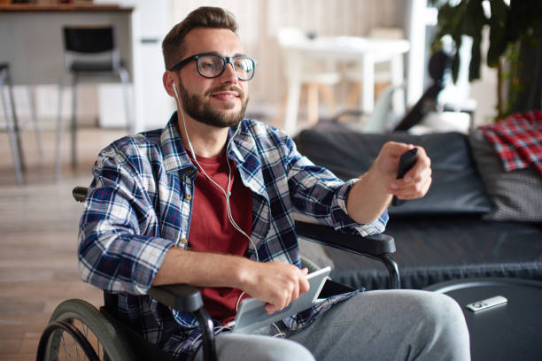 istock Handicapped young man with tablet at home 1420420401