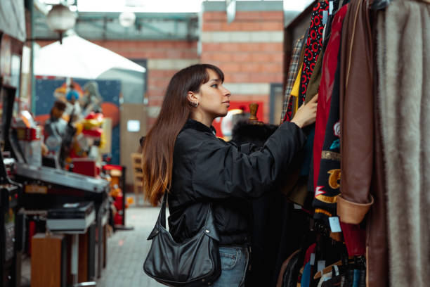 Young woman shopping vintage clothing stock photo