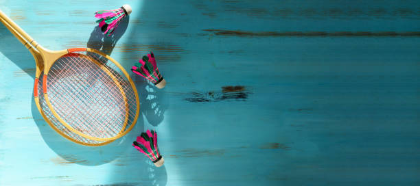 istock Shuttlecocks and badminton rackets on blue wooden background. Flat lay. Copy space 1420431015
