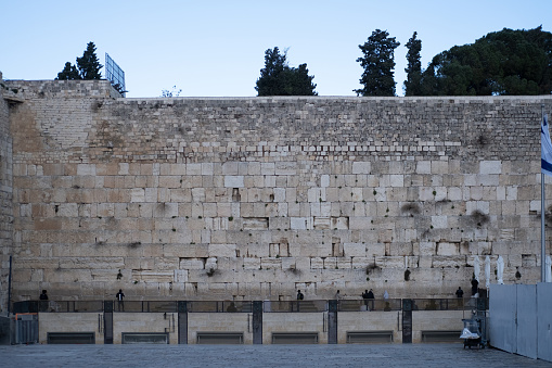 Praying at the Wailing Wall Jerusalem Israel. The Western Wall, Wailing Wall or Kotel  is located in the Old City of Jerusalem. It is a relatively small western segment of the walls surrounding the area called the Temple Mount by Jews, Christians and most Western sources, and known to Muslims as the Noble Sanctuary. 