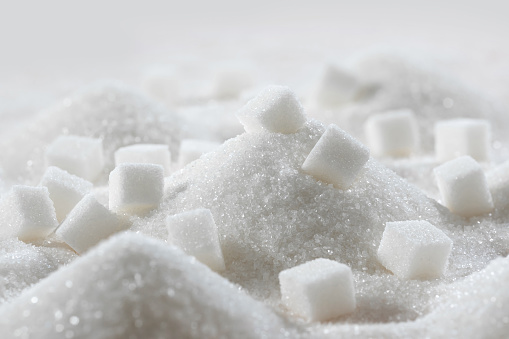 White granulated sugar and refined sugar cubes close-up in the kitchen