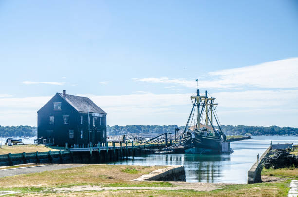 Salem Maritime National Historic Site during summer day\nSailing ship name is Friendship of Salem.\nThe building besides is Pedrick Store House