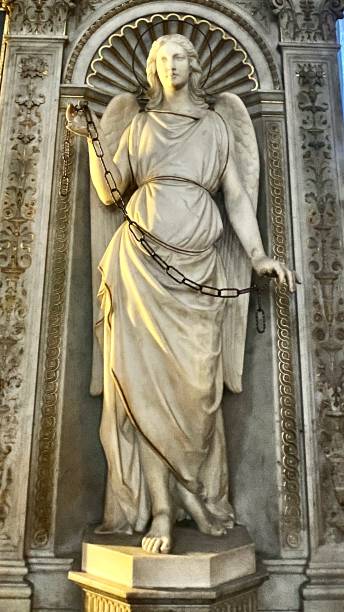 à l’intérieur de la basilique de san pietro di vincoli, une statue en marbre de sainte-catherine tient un ensemble emblématique de chaînes noires à côté du reliquaire doré contenant les chaînes réelles qui ont tenu san pietro en prison. - pope julius ii photos et images de collection