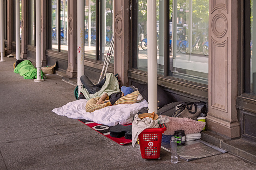 Manhattan, New York, NY, USA - July 10th 2022: Row of homeless people camping on the side walk of Cooper Square