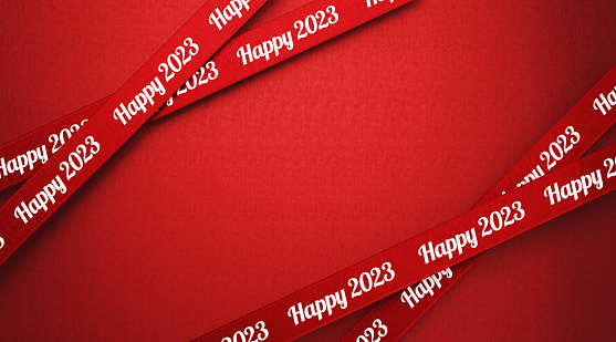 Happy 2023 written red ribbons over red background. Horizontal composition with copy space. 2023 concept.