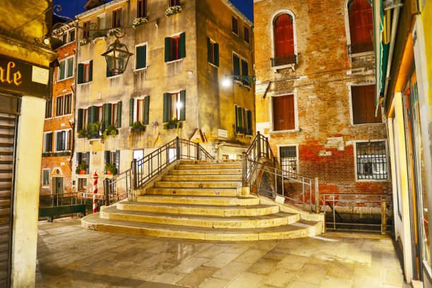 Beautiful stone bridge over the canal in a quiet street, Venice, Italy