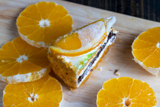 sliced fresh oranges and a piece of orange dessert, orange cake with juicy oranges on the table