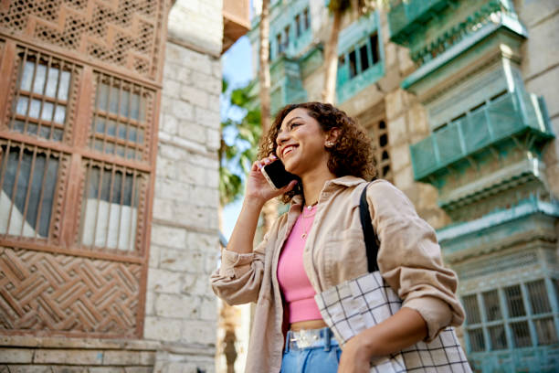 istock Young woman walking through Al-Balad using smart phone 1420486880