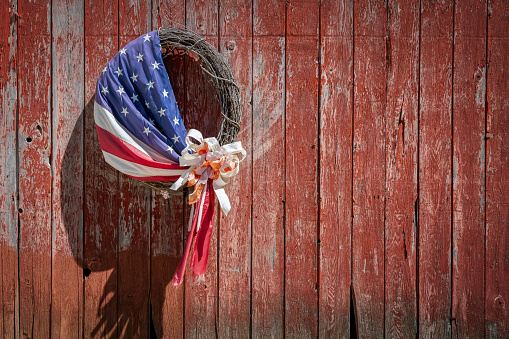 An American flag wrapped around a wreath made of sticks hangs on the side of a barn near Manitowoc, Wisconsin.