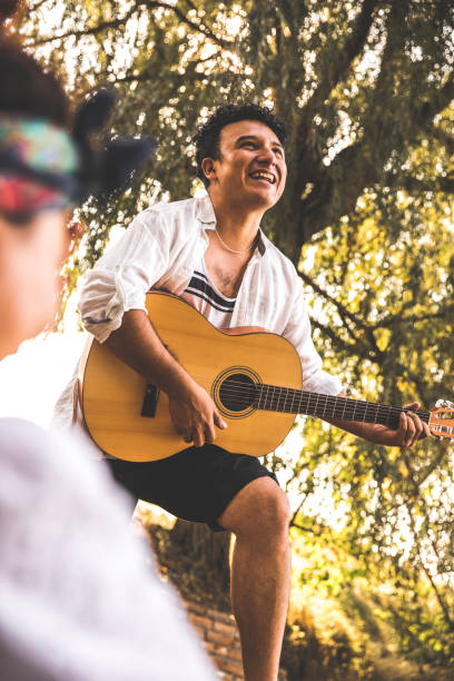 istock Smiling young man playing the guitar and singing 1420487323