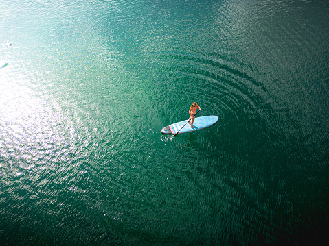 Aerial view of a woman exercising on a stand up paddle board