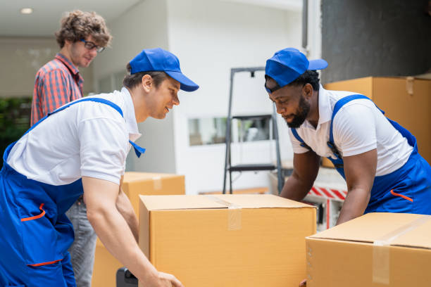 istock Man movers worker in blue uniform unloading cardboard boxes from truck.Professional delivery and moving service. 1420489465