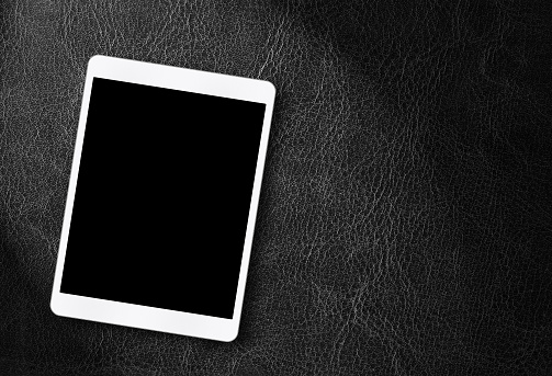 Blank white digital tablet on leather background