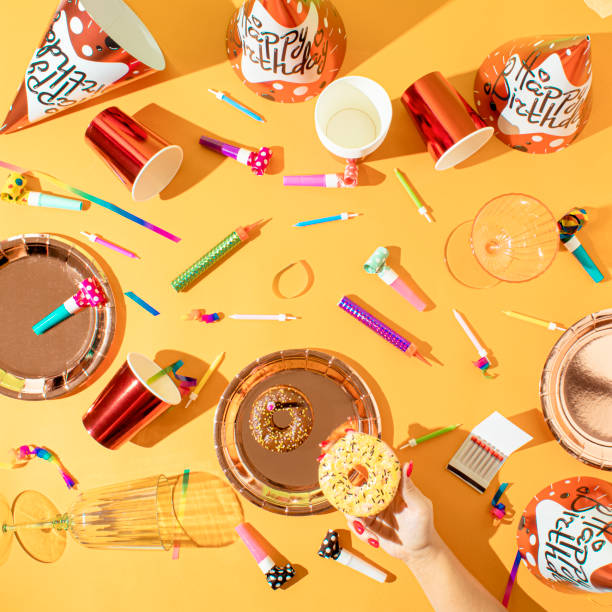 Creative Birthday party concept of caps, paper straws, candy, balloons  blowers and confetti. Colorful background.