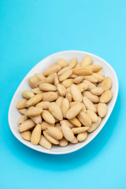 clean almonds on small white dish on blue