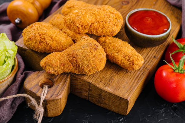istock Fried chicken with ketchup on a wooden board 1420504536
