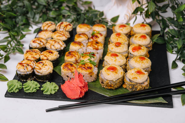istock Served warm sushi with ginger and wasabi on a black stone plate 1420505021