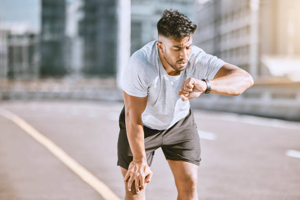 istock Fitness, tired and runner checking watch for running speed, pace and time in routine workout, exercise and city training. Fit, active and healthy man monitoring wellness, endurance and cardio health 1420515140