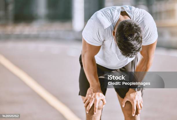 Tired Man Resting After Fitness Run Taking A Break From Cardio Training And Doing Wellness Exercise On The Road In The Urban City Exhausted And Fit Sports Person Doing Routine Workout In Street Stock Photo - Download Image Now