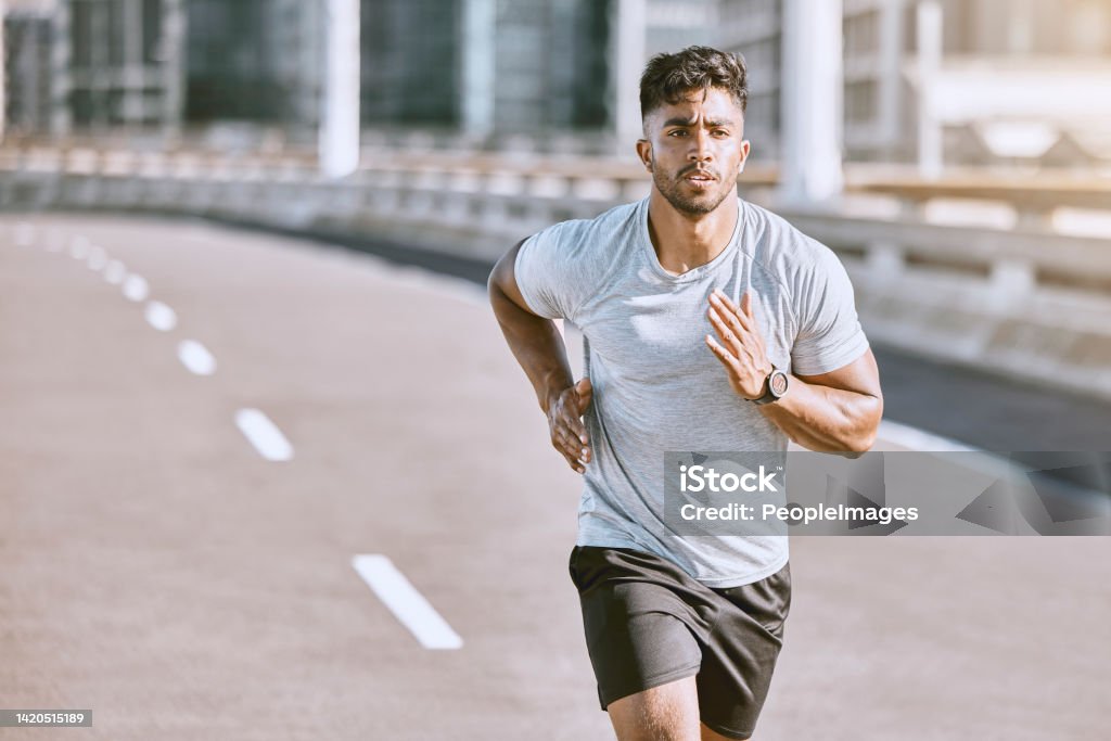 Exercise, workout and training with a healthy man training for sport, fitness and wellness outside in the city. Running, exercising and working out with motivation for lifestyle, health and sports Men Stock Photo