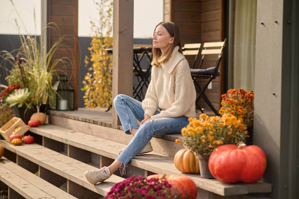 istock Attractive long-haired lady seated outside the house 1420520822