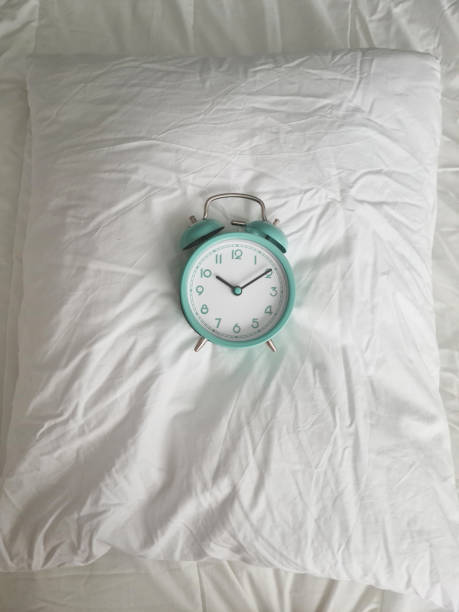 istock Alarm clock for ten o'clock on white pillow in bed 1420521553