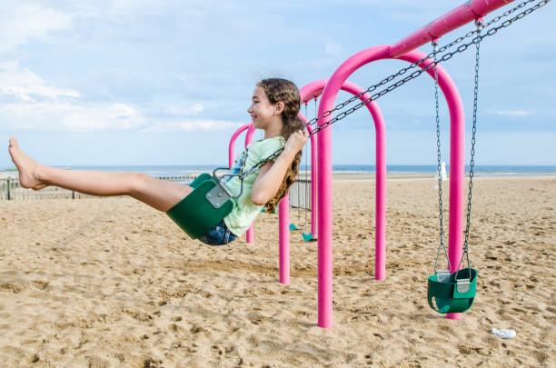 Teenage girl having fun in swing stock photo
