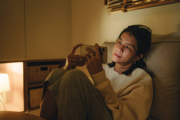 istock Young woman using smart phone in bed 1420529159