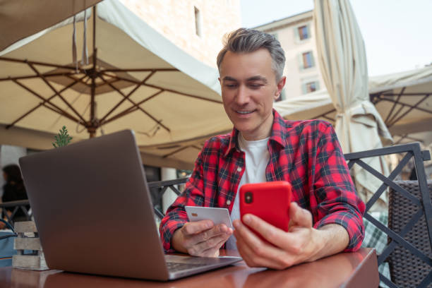 istock Man sitting with a phone in hand and holding a sim card 1420533926