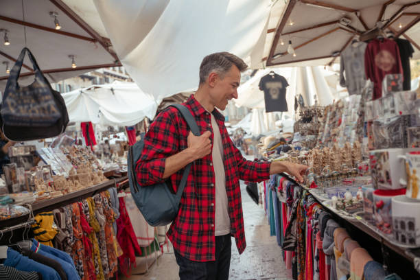 istock Mid aged man choosing souvenirs in the outdoors market 1420533956