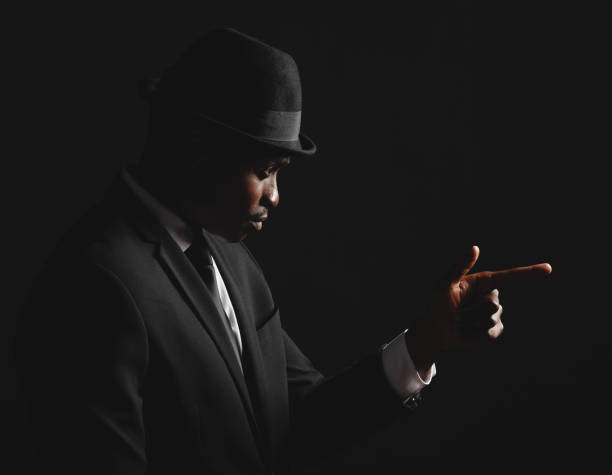 istock Dapper and confident young man dressed in formal attire against a dark background. Handsome african american male looking stylish and sophisticated isolated on black. Looking very classy and debonair 1420534986