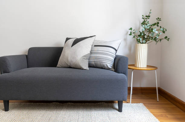 istock Stylish home interior with comfortable pillow on sofa, coffee table, plants and carpet. 1420543023