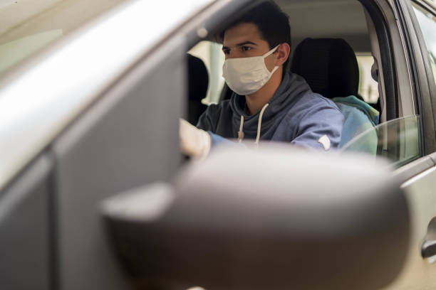 istock Man driving his car with a protection mask 1420544584