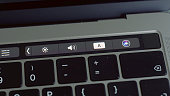 Close up of a finger unblocking modern laptop with touch id technology. Action. Using male fingerprint to activate system of macbook, computer technologies concept.