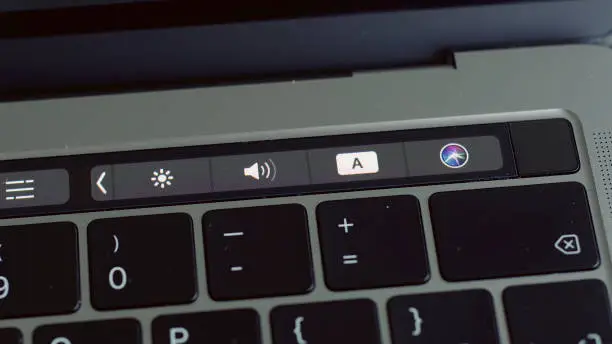 Photo of Close up of a finger unblocking modern laptop with touch id technology. Action. Using male fingerprint to activate system of macbook, computer technologies concept.