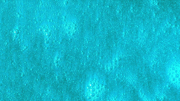 fundo turquesa brilhante com bolhas se movendo lentamente. bela superfície azul com partículas brilhantes fluindo. - water ripple drop zen like - fotografias e filmes do acervo