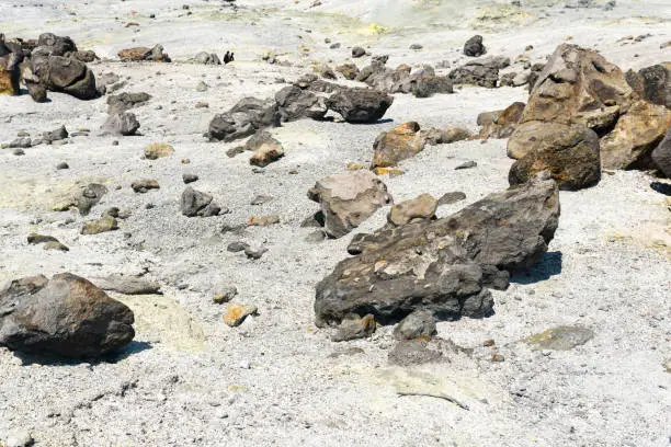 volcanic bombs among the tephra in a fumarole field on the slope of a volcano