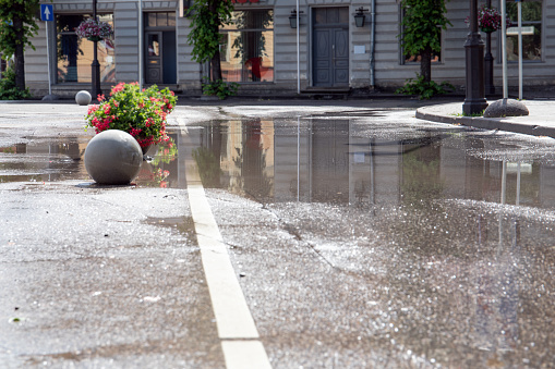 Streets after heavy summer rain with puddles, extrem wather and urban drainage system concept