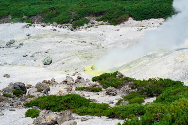 crystallized sulfur around a solfatara in the fumarole field on the slope of a volcano
