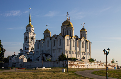the ancient white-stone Assumption Cathedral with shining golden domes on a bright sunny summer day in Vladimir