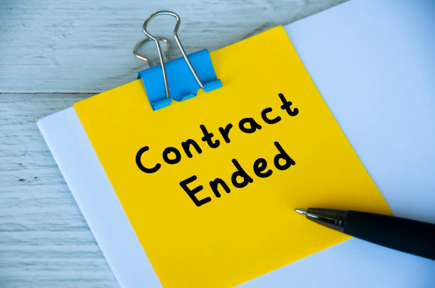 istock Contract ended text on yellow notepad with white paper and wooden table background. Employment and contract workers concept 1420550049
