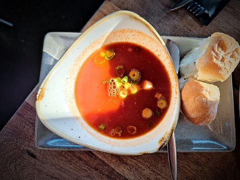 Bowl of thick tomato soup with crusty bread