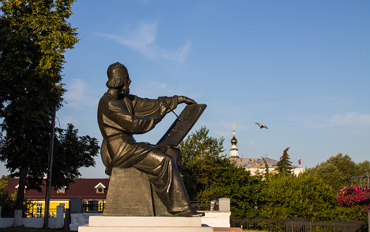 Bronze monument to the great Russian icon painter Andrei Rublev on the old town square among green trees on a summer day in Vladimir made by the author sculptor Oleg Komov in 1995