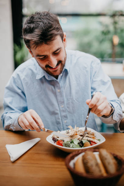 istock Man eating a salad in restaurant 1420554043